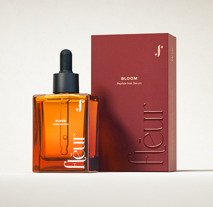 bloom peptide hair+scalp serum in amber glass bottle with black dropper next to dark red rectangular box packaging